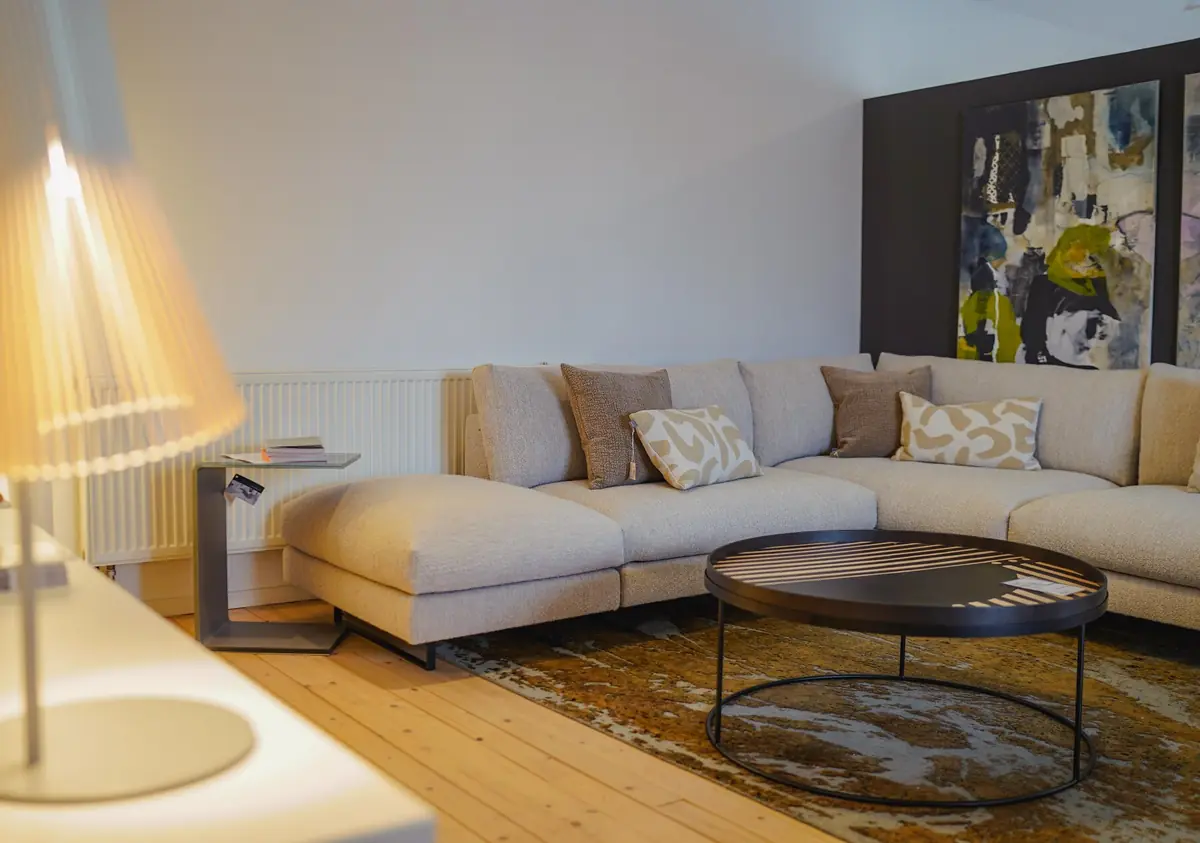 Hochwertiges Sofa mit Beistelltisch und Stehleuchte in warmem Ambiente