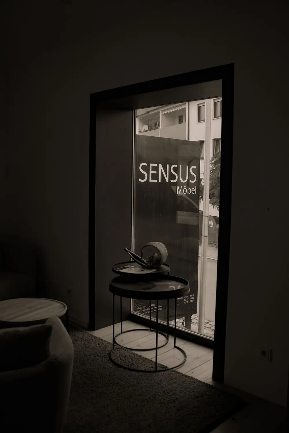 Eingang der Sensus-Möbel-Ausstellung mit Logo an der Glastür